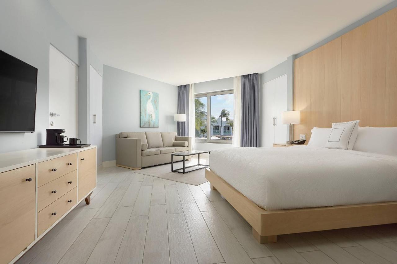 Habitación con cama extragrande, sofá cama y vistas a la piscina