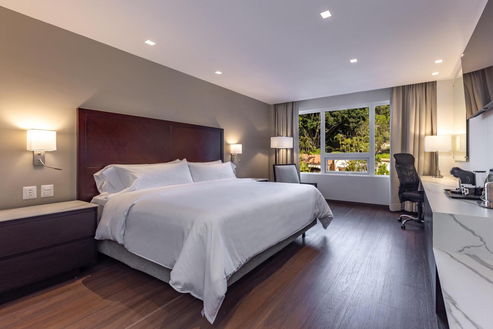 Habitación con cama grande y vistas al jardín